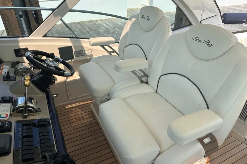 Slide: The Image of 2007 Sea Ray 48 Sundancer helm with dual white leather seats and control panel. - 11