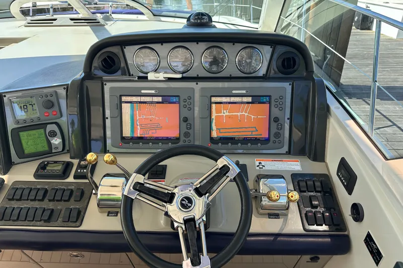 Slide: The Image of Cockpit of 2007 Sea Ray 48 Sundancer with navigation screens and controls. - 8