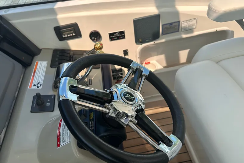 Slide: The Image of Steering wheel of a 2007 Sea Ray 48 Sundancer yacht, showcasing luxury controls. - 12
