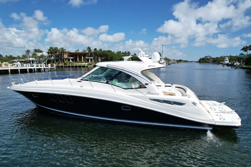 Slide: The Image of 2007 Sea Ray 48 Sundancer yacht cruising on a scenic waterway under a clear blue sky. - 88