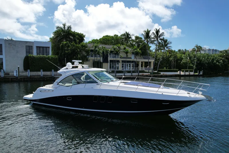 Slide: The Image of 2007 Sea Ray 48 Sundancer yacht cruising on a sunny day near waterfront homes. - 2