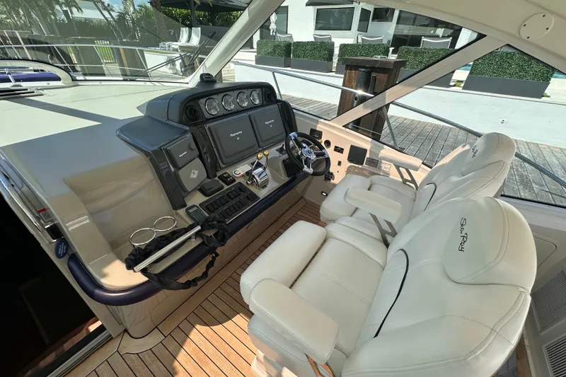 Slide: The Image of 2007 Sea Ray 48 Sundancer helm with dual white seats and modern dashboard controls. - 10