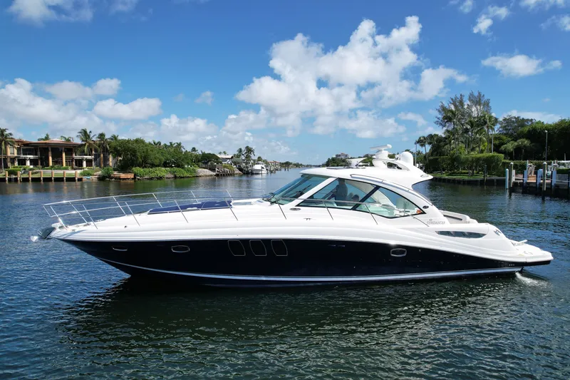 Slide: The Image of 2007 Sea Ray 48 Sundancer yacht cruising on a scenic waterway under a clear blue sky. - 1