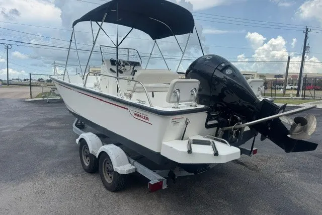 Slide: The Image of 2022 Boston Whaler 190 Montauk boat on trailer, featuring outboard motor and canopy. - 6