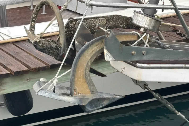 Slide: The Image of Anchors on a 1989 Island Packet 35 sailboat docked at a wooden pier. - 18