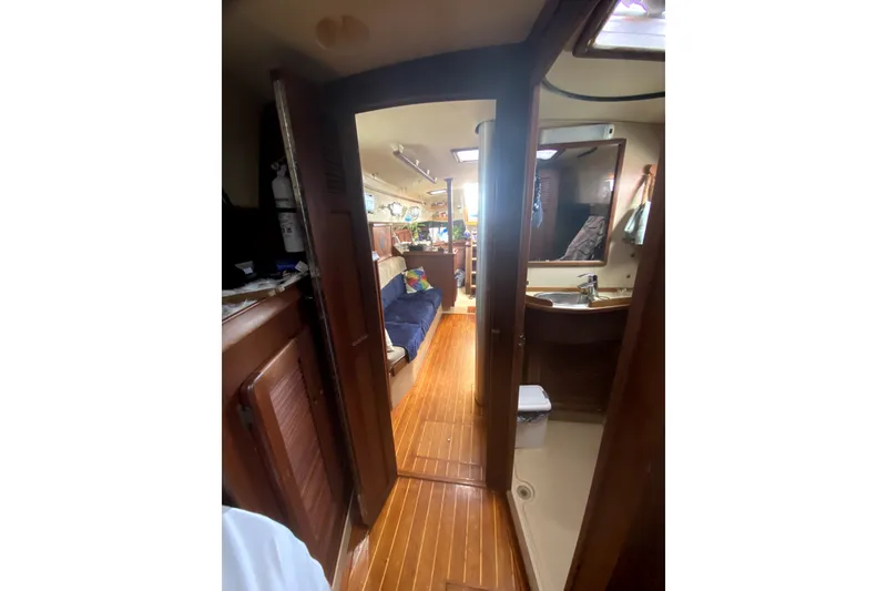 Slide: The Image of Interior view of 1989 Island Packet 35 sailboat, featuring wooden flooring and cozy seating area. - 9