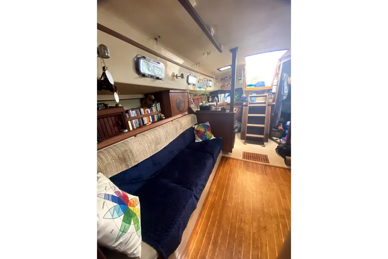 Slide: The Image of Interior of 1989 Island Packet 35 sailboat with cozy seating and wooden flooring. - 4