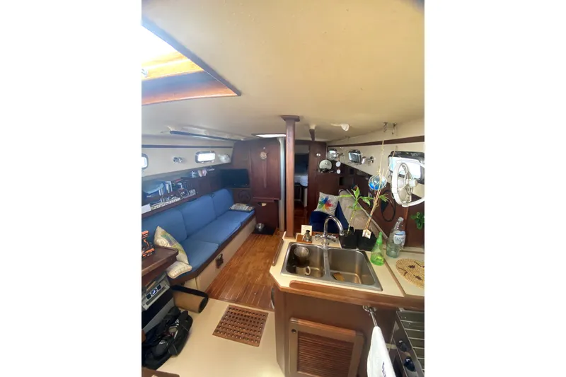 Slide: The Image of Interior of 1989 Island Packet 35 sailboat with cozy seating and kitchen area. - 3