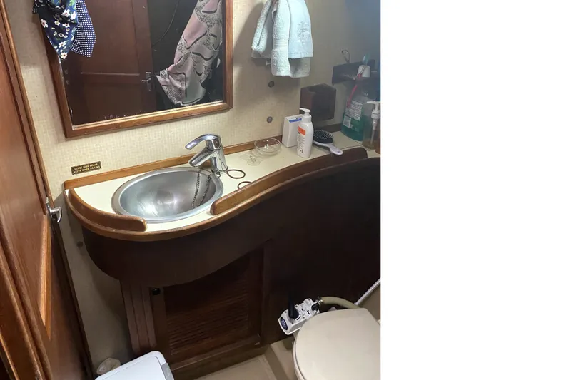 Slide: The Image of 1989 Island Packet 35 yacht bathroom with sink, mirror, and toiletries. - 13