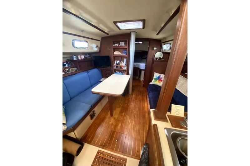 Slide: The Image of Interior of 1989 Island Packet 35 sailboat with cozy seating and wooden finishes. - 5