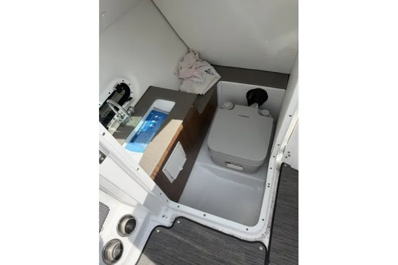 Slide: The Image of 2022 Four Winns HD5 OB boat interior with compact toilet and sink area. - 10