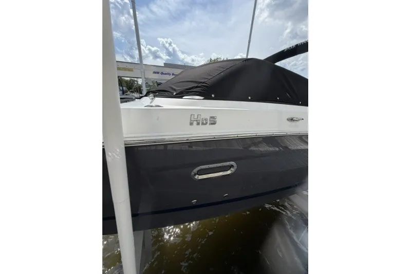 Slide: The Image of 2022 Four Winns HD5 OB boat with cover, docked under cloudy sky. - 4