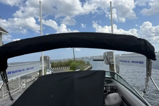 Slide: The Image of 2022 Four Winns HD5 OB boat docked with canopy under a partly cloudy sky. - 29