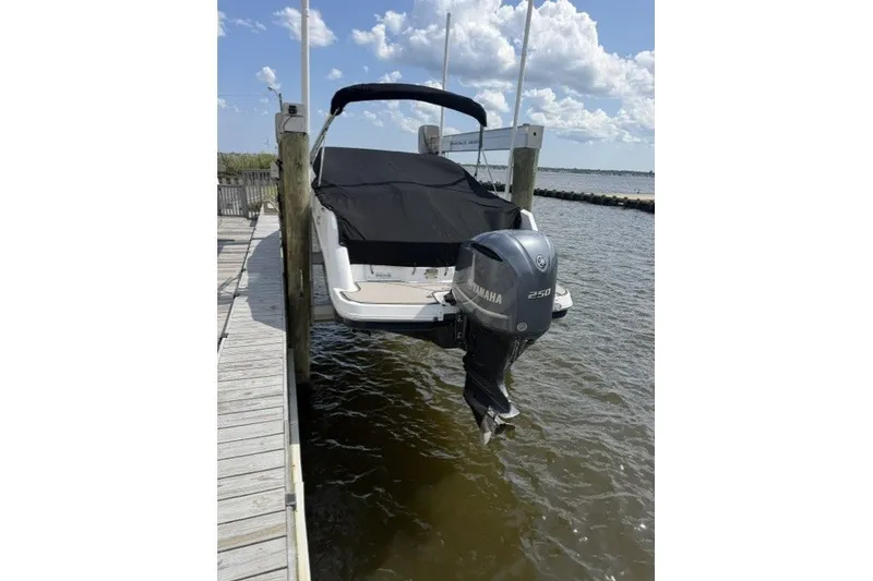 Slide: The Image of 2022 Four Winns HD5 OB boat with Yamaha 250 engine docked by the water. - 3