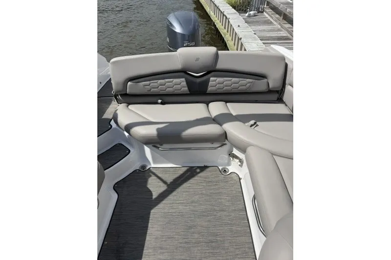 Slide: The Image of 2022 Four Winns HD5 OB boat interior with gray seating and outboard motor. - 22