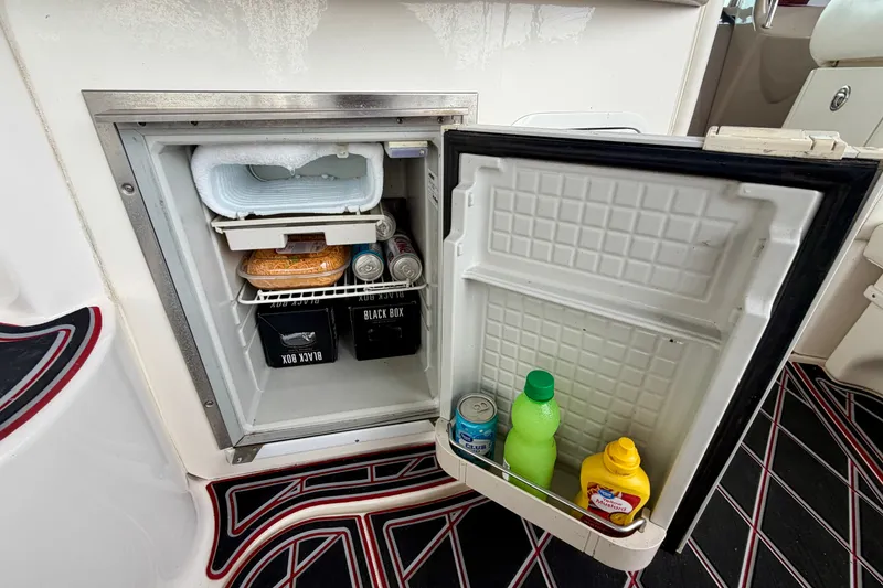 Slide: The Image of Mini fridge on 2003 Sea Ray Sundancer 320, stocked with drinks and condiments. - 19