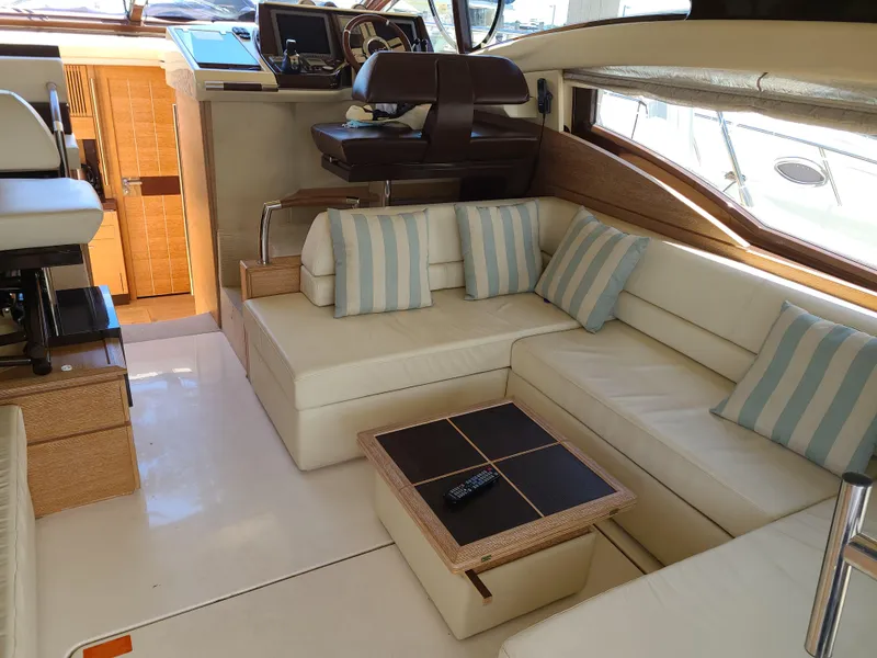 Slide: The Image of Luxurious interior of a 2011 Azimut 47 yacht with white leather seating and striped cushions. - 32