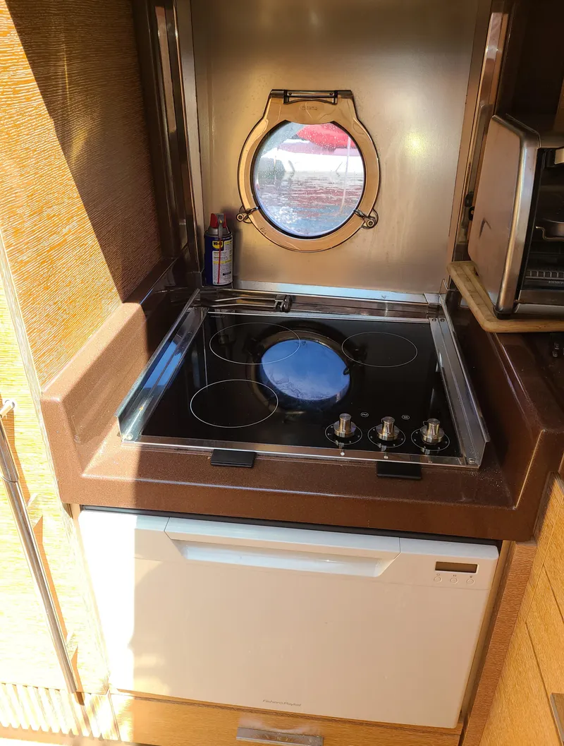 Slide: The Image of Compact kitchen area in a 2011 Azimut 47 yacht with stove and porthole. - 40