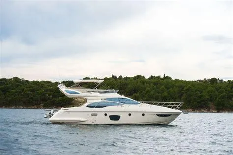 The Image of 2011 Azimut 47 yacht cruising on a calm sea near a forested shoreline. - 0