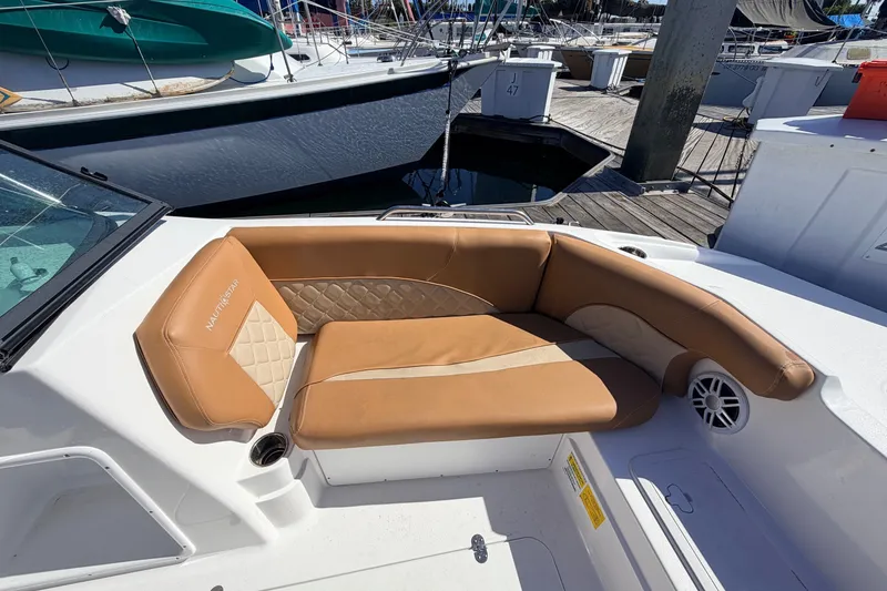 Slide: The Image of Luxurious seating on 2026 NauticStar 203 DC Deck boat, featuring tan upholstery and elegant design. - 21
