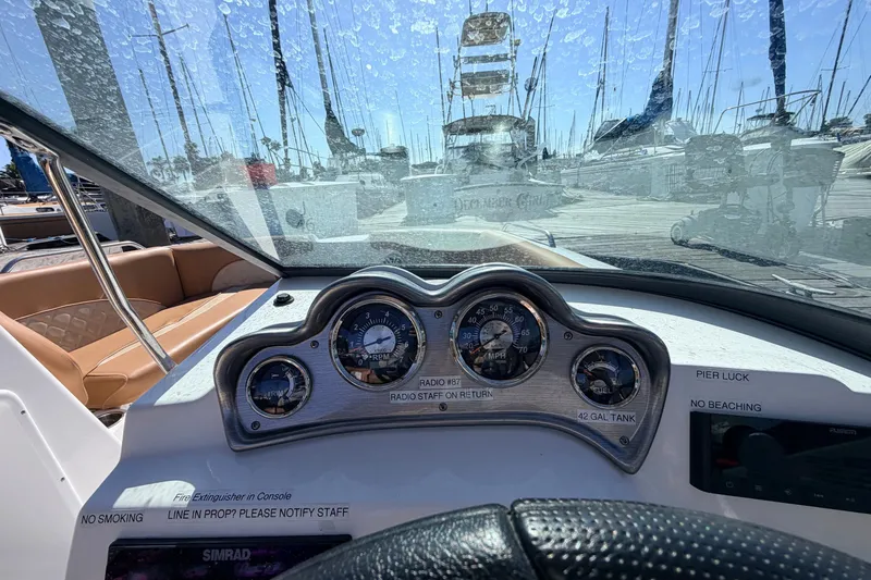Slide: The Image of Dashboard view of a 2026 NauticStar 203 DC Deck boat at a marina. - 14