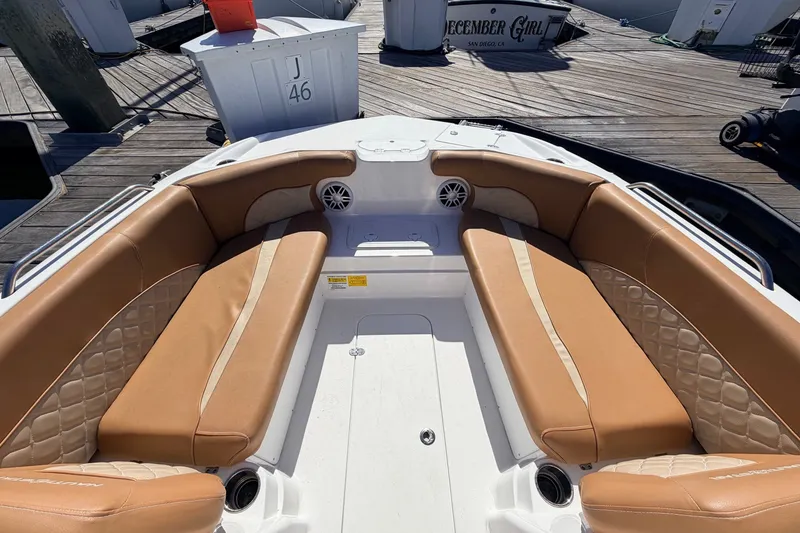 Slide: The Image of 2026 NauticStar 203 DC Deck boat with tan seating at dock. - 20