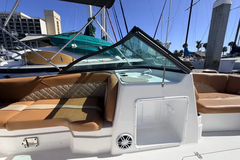 Slide: The Image of 2026 NauticStar 203 DC Deck boat interior with tan seating and storage compartment. - 16