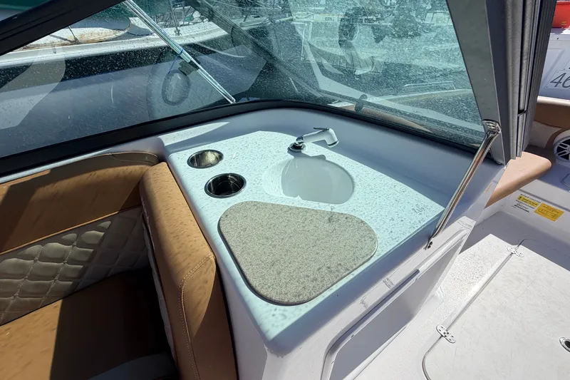 Slide: The Image of Interior view of 2026 NauticStar 203 DC Deck boat featuring a sink and cup holders. - 17