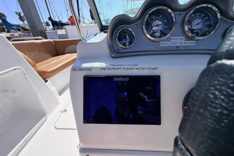 Slide: The Image of 2026 NauticStar 203 DC Deck boat dashboard with gauges and Simrad display. - 15