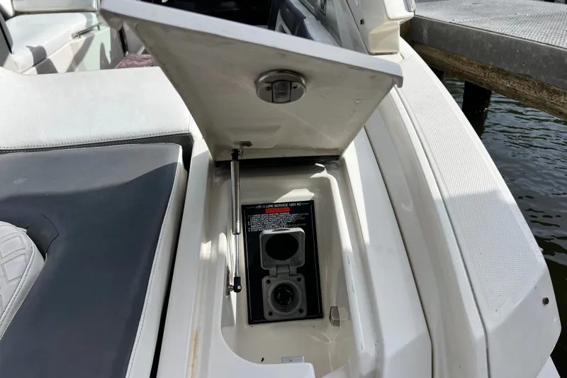 Slide: The Image of Open storage compartment on 2011 Monterey 328SS Super Sport boat, showing electrical outlet. - 18