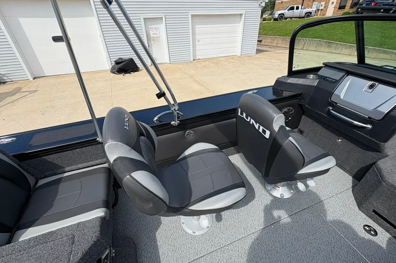 Slide: The Image of 2025 Lund 1875 Pro-V boat interior with gray seating and modern dashboard. - 34