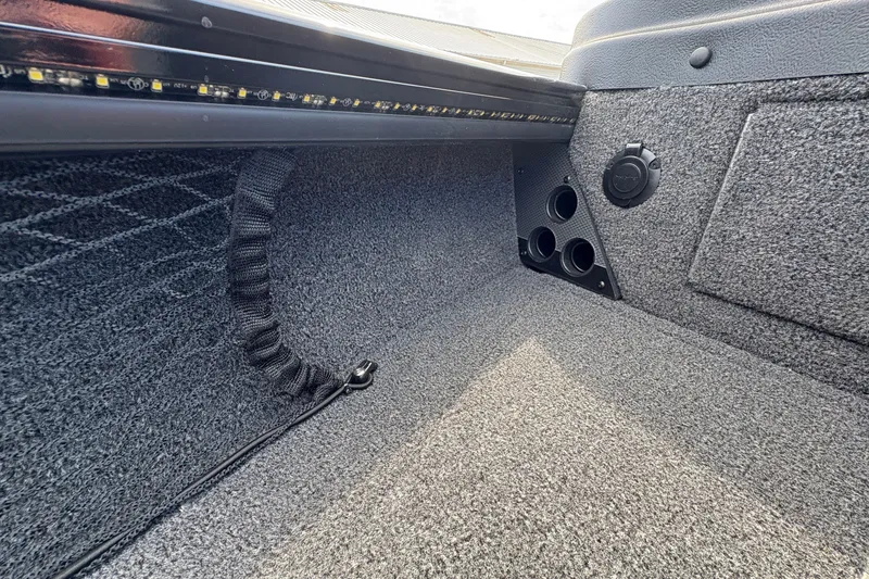 Slide: The Image of Interior view of 2025 Lund 1875 Pro-V boat, featuring carpeted storage area and netting. - 16