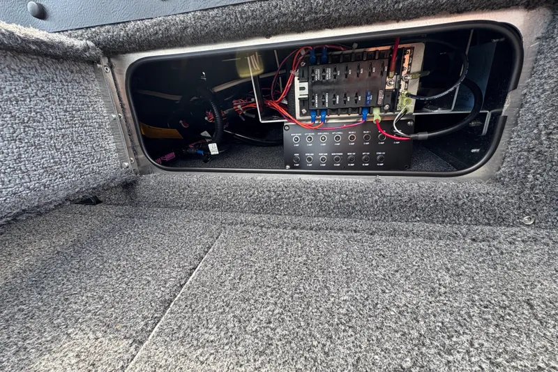 Slide: The Image of Electrical panel inside 2025 Lund 1875 Pro-V boat, showcasing wiring and fuse box. - 17