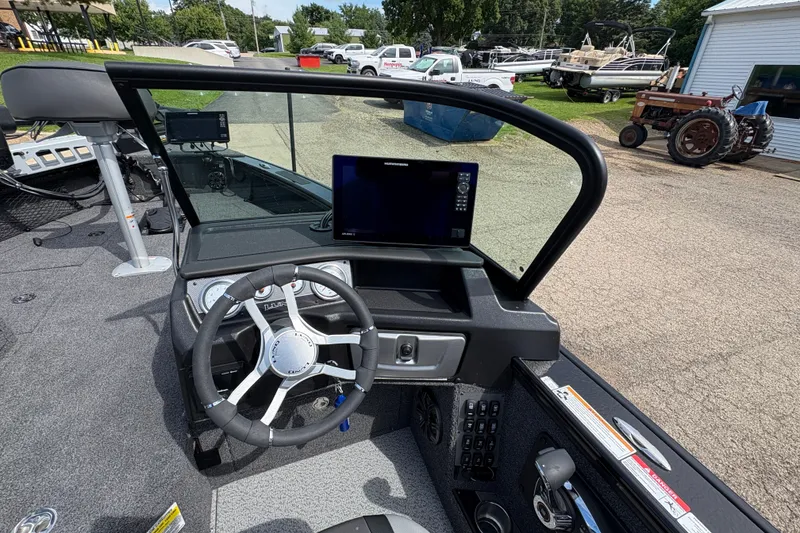 Slide: The Image of 2025 Lund 1875 Pro-V boat dashboard with steering wheel and electronic display. - 21