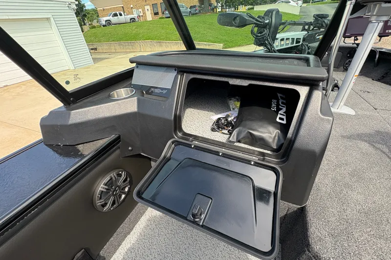 Slide: The Image of 2025 Lund 1875 Pro-V boat interior with open storage compartment and speaker. - 29