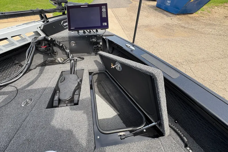Slide: The Image of 2025 Lund 1875 Pro-V boat interior with open storage compartment and electronic display. - 13