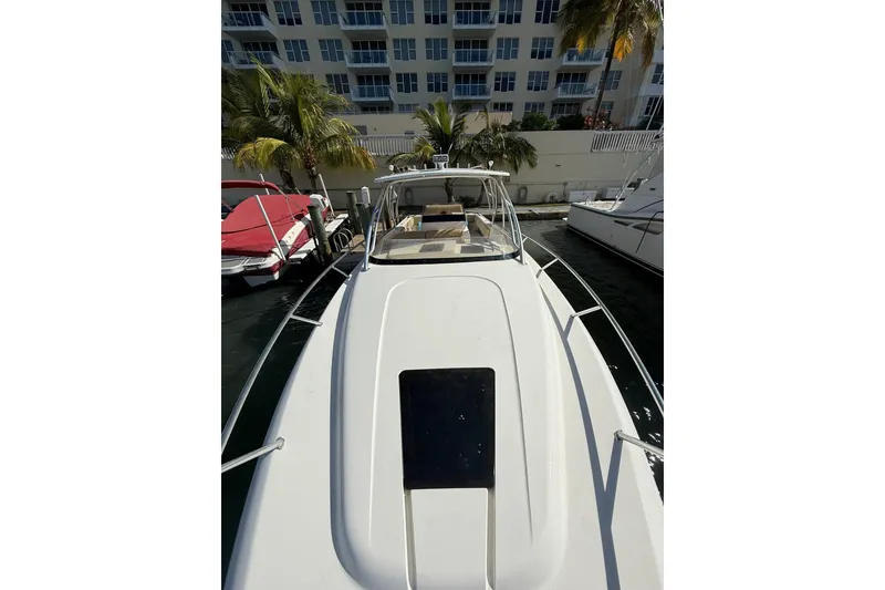 Slide: The Image of 2008 Intrepid 370 Cuddy boat docked near waterfront buildings and palm trees. - 41