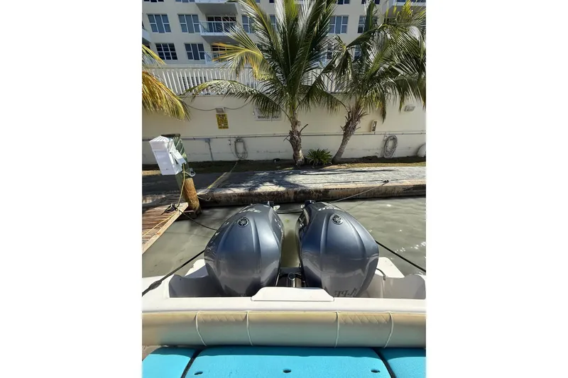 Slide: The Image of 2008 Intrepid 370 Cuddy boat with dual outboard engines docked near palm trees. - 25