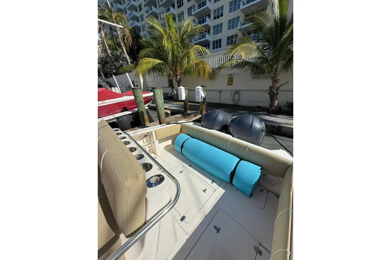 Slide: The Image of 2008 Intrepid 370 Cuddy boat docked, featuring seating and palm trees in the background. - 24