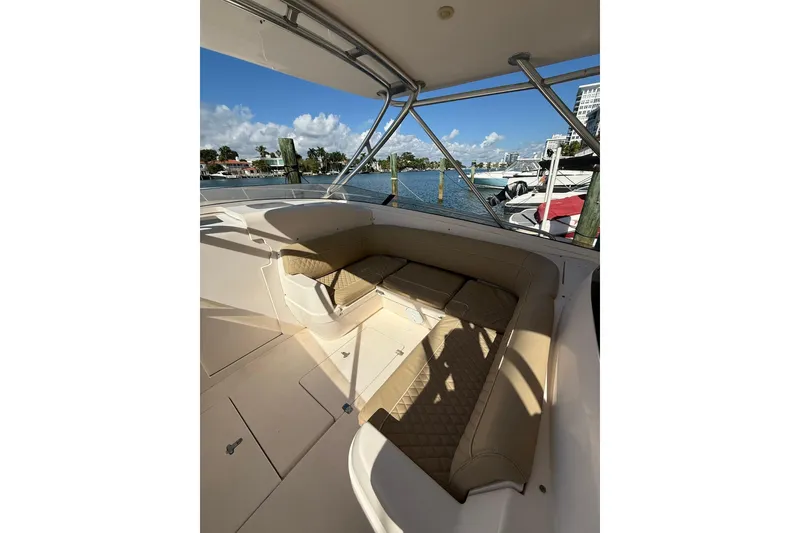 Slide: The Image of 2008 Intrepid 370 Cuddy boat interior with cushioned seating and waterfront view. - 29