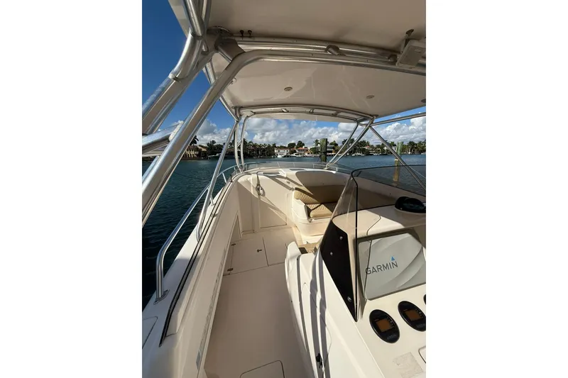 Slide: The Image of 2008 Intrepid 370 Cuddy boat interior with Garmin navigation, docked by waterfront homes. - 27