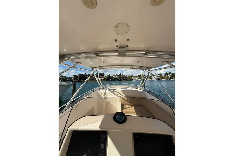 Slide: The Image of 2008 Intrepid 370 Cuddy boat interior with helm view, overlooking serene waterfront. - 21