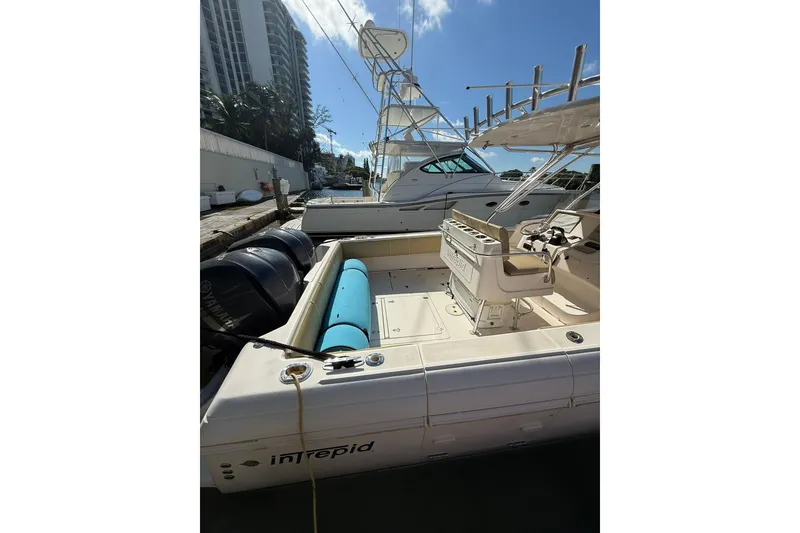 Slide: The Image of 2008 Intrepid 370 Cuddy boat docked, featuring spacious deck and dual outboard engines. - 4