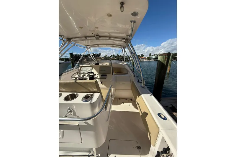 Slide: The Image of 2008 Intrepid 370 Cuddy boat interior with helm, docked by the water. - 12