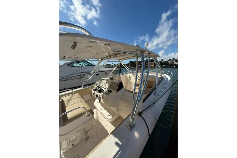 Slide: The Image of 2008 Intrepid 370 Cuddy boat with sleek design, docked under clear blue sky. - 7