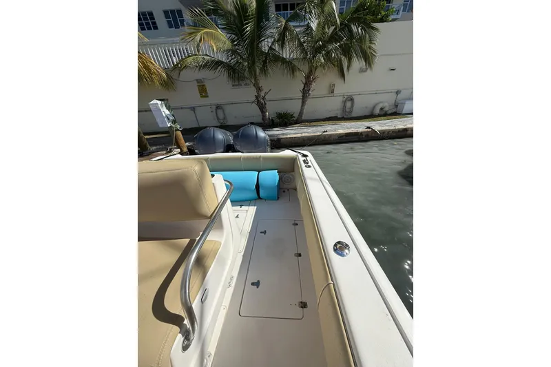 Slide: The Image of 2008 Intrepid 370 Cuddy boat interior with seating, docked near palm trees. - 23