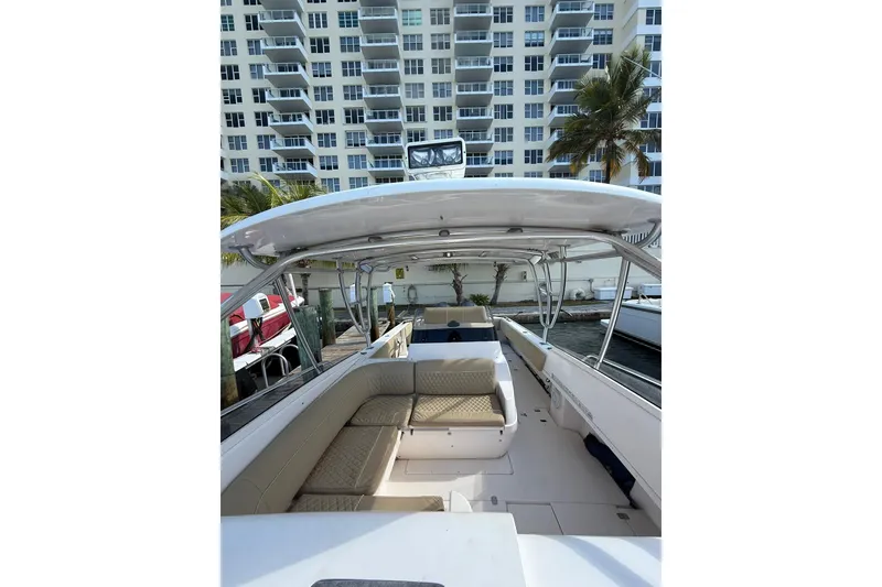 Slide: The Image of 2008 Intrepid 370 Cuddy boat interior with seating, docked near waterfront building. - 43