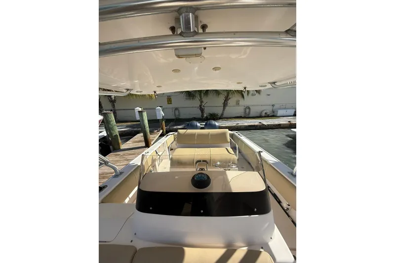 Slide: The Image of 2008 Intrepid 370 Cuddy boat interior with seating and helm, docked by the water. - 36