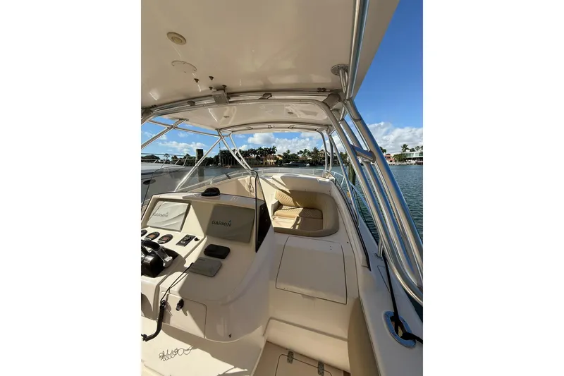Slide: The Image of 2008 Intrepid 370 Cuddy boat interior with Garmin navigation, docked by waterfront homes. - 13