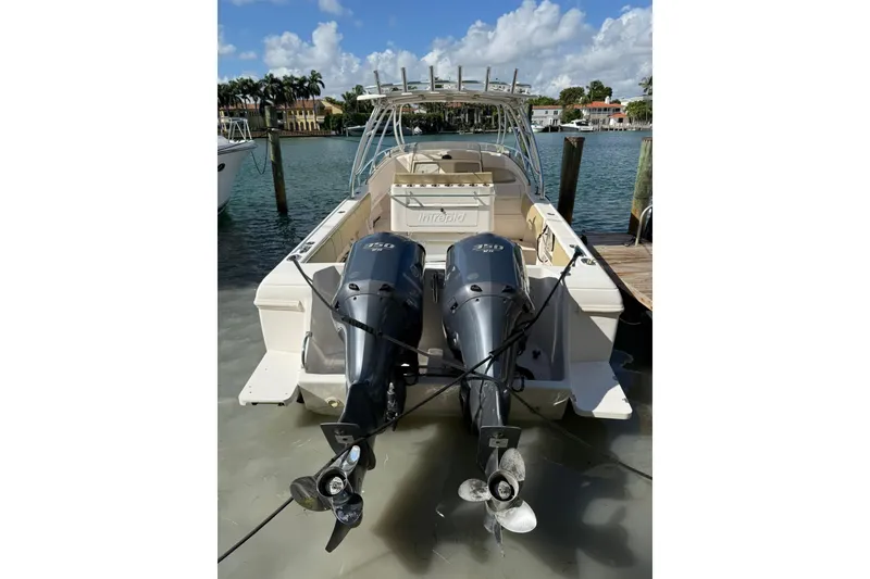 Slide: The Image of 2008 Intrepid 370 Cuddy boat with dual outboard engines docked by the water. - 1